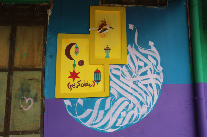  سكان حارة قديمة في «غزة» يحولون جدرانها  إلى لوحات فنية ترحب بشهر رمضان 